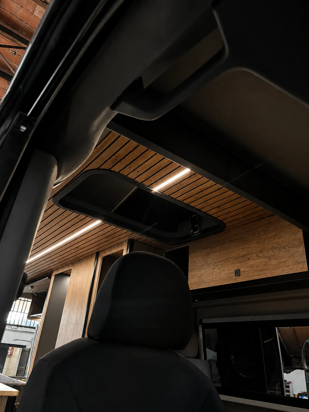 Habitáculo de camper con molduras de techo abatibles e iluminación LED lineal integrada